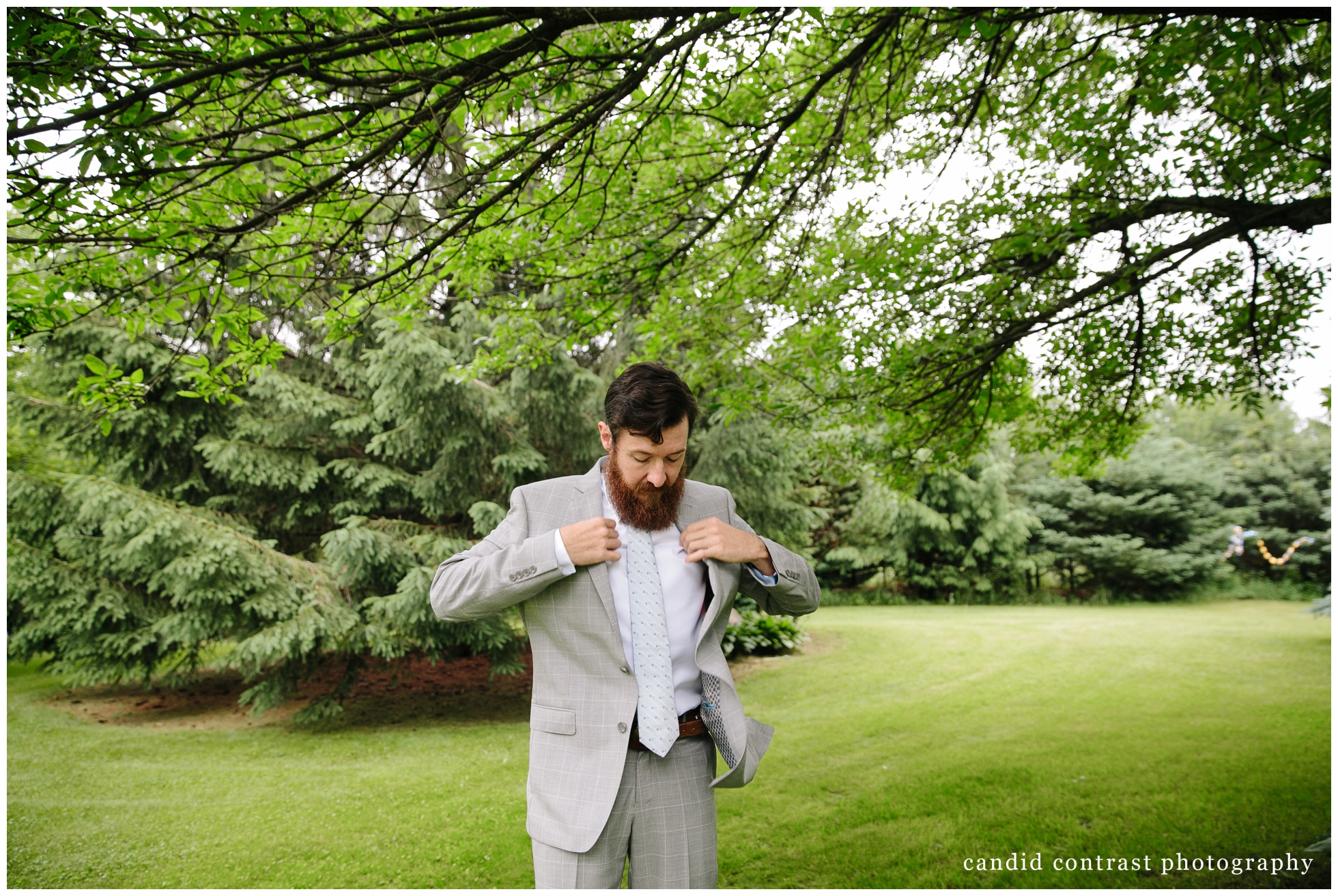 groom getting ready at backyard wedding in dubuque, ia, candid contrast photography