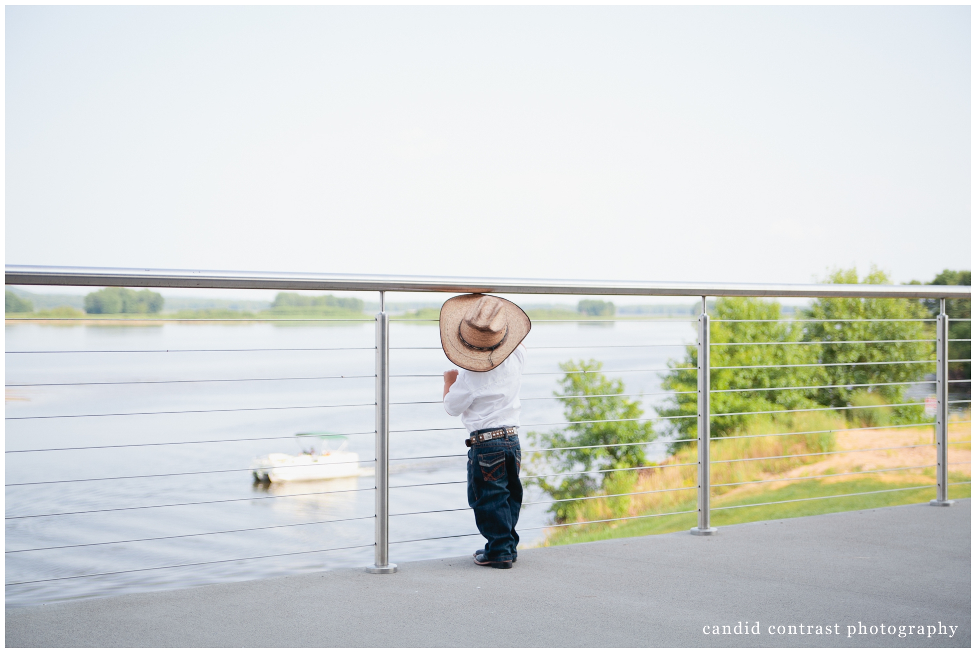 getting ready for Bellevue Iowa wedding at The Shore Event Centre, little cowboy looks out at Mississippi river, iowa wedding photographer candid contrast photography
