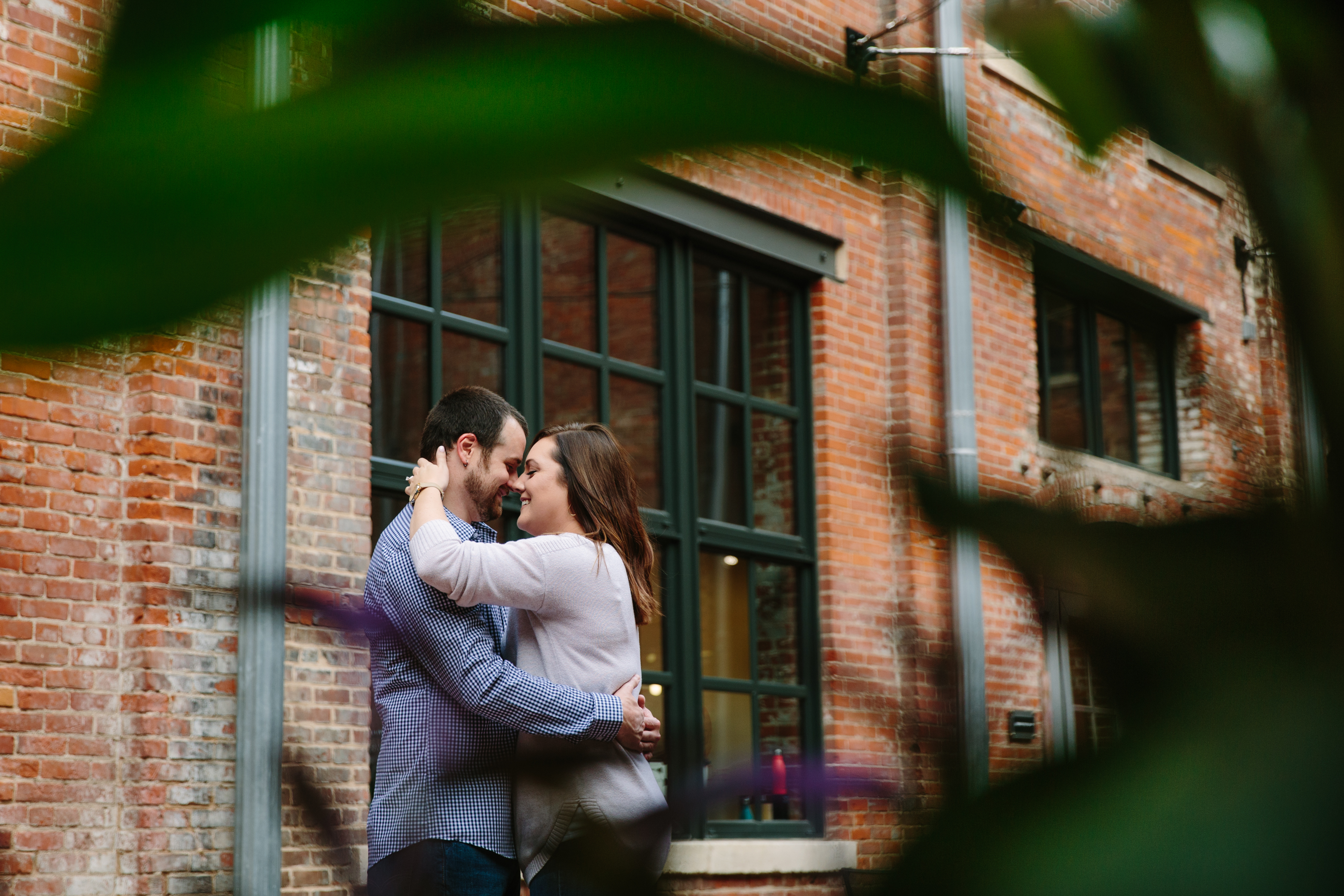 dubuque engagement session by catherine furlin photography, couple snuggling in millwork district
