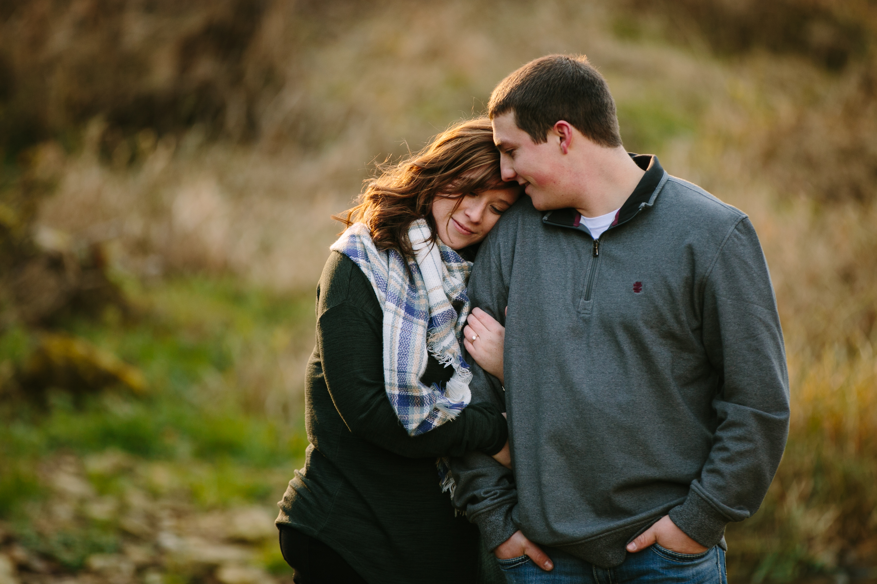 couple snuggling, iowa farm engagement session by catherine furlin photography
