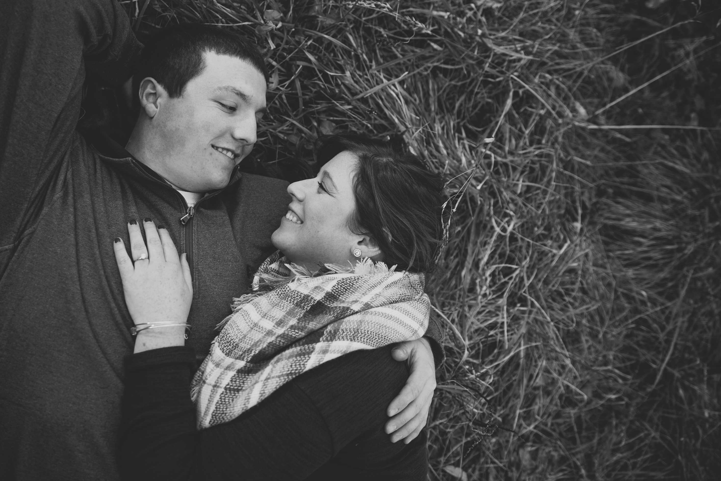 couple laying in the grass, iowa farm engagement session by catherine furlin photography