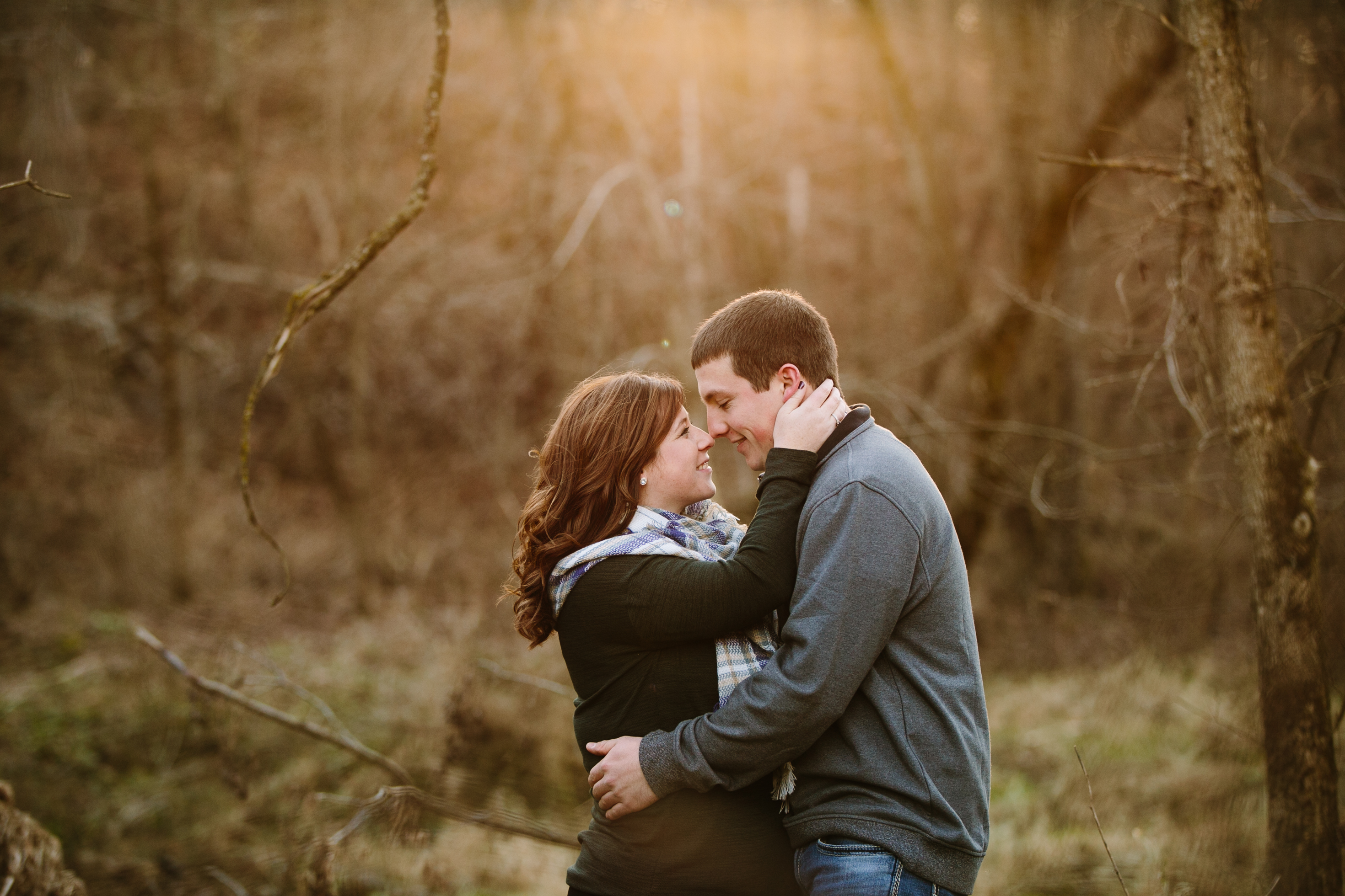 couple snuggling, iowa farm engagement session by catherine furlin photography