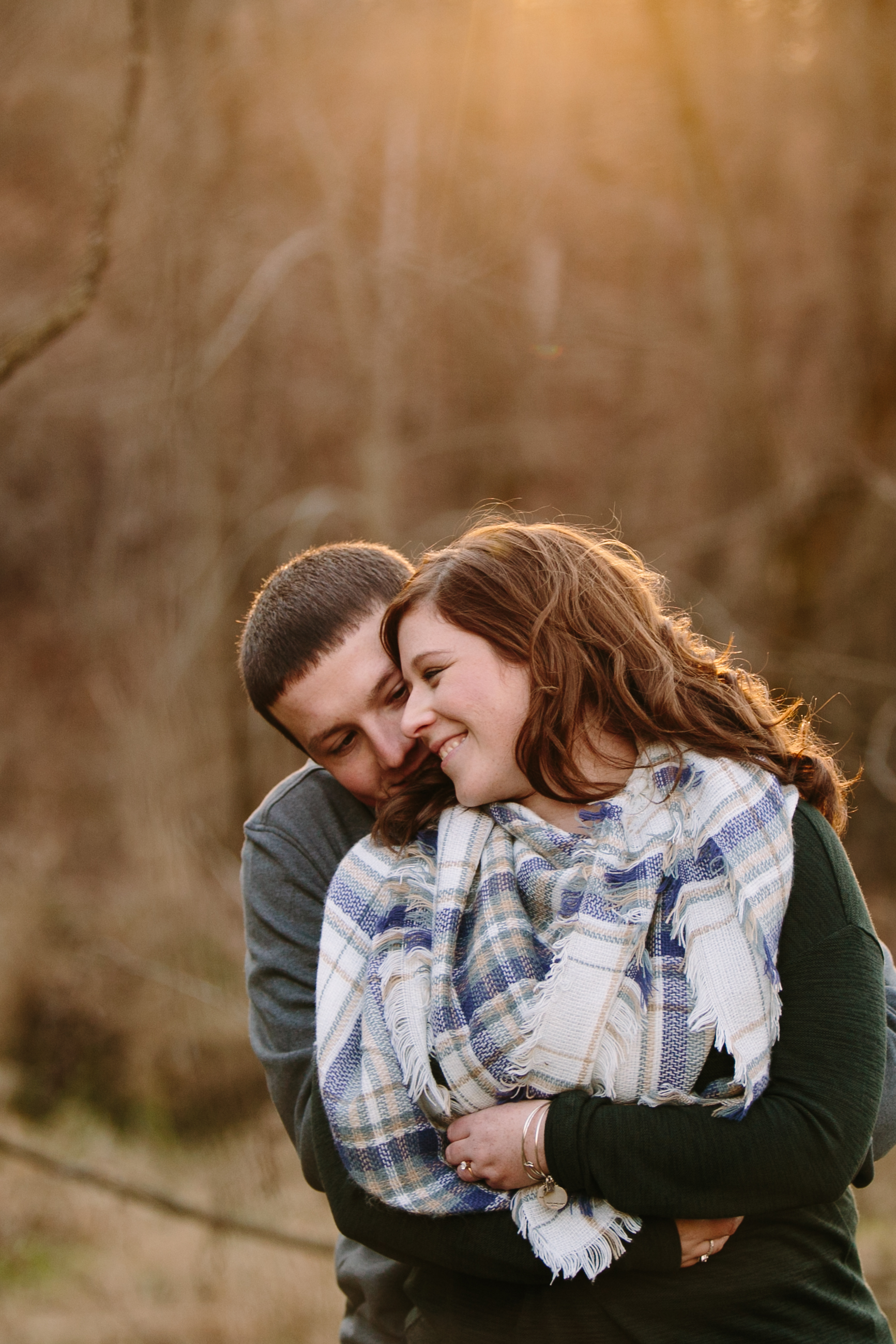 couple staying warm, iowa farm engagement session by catherine furlin photography