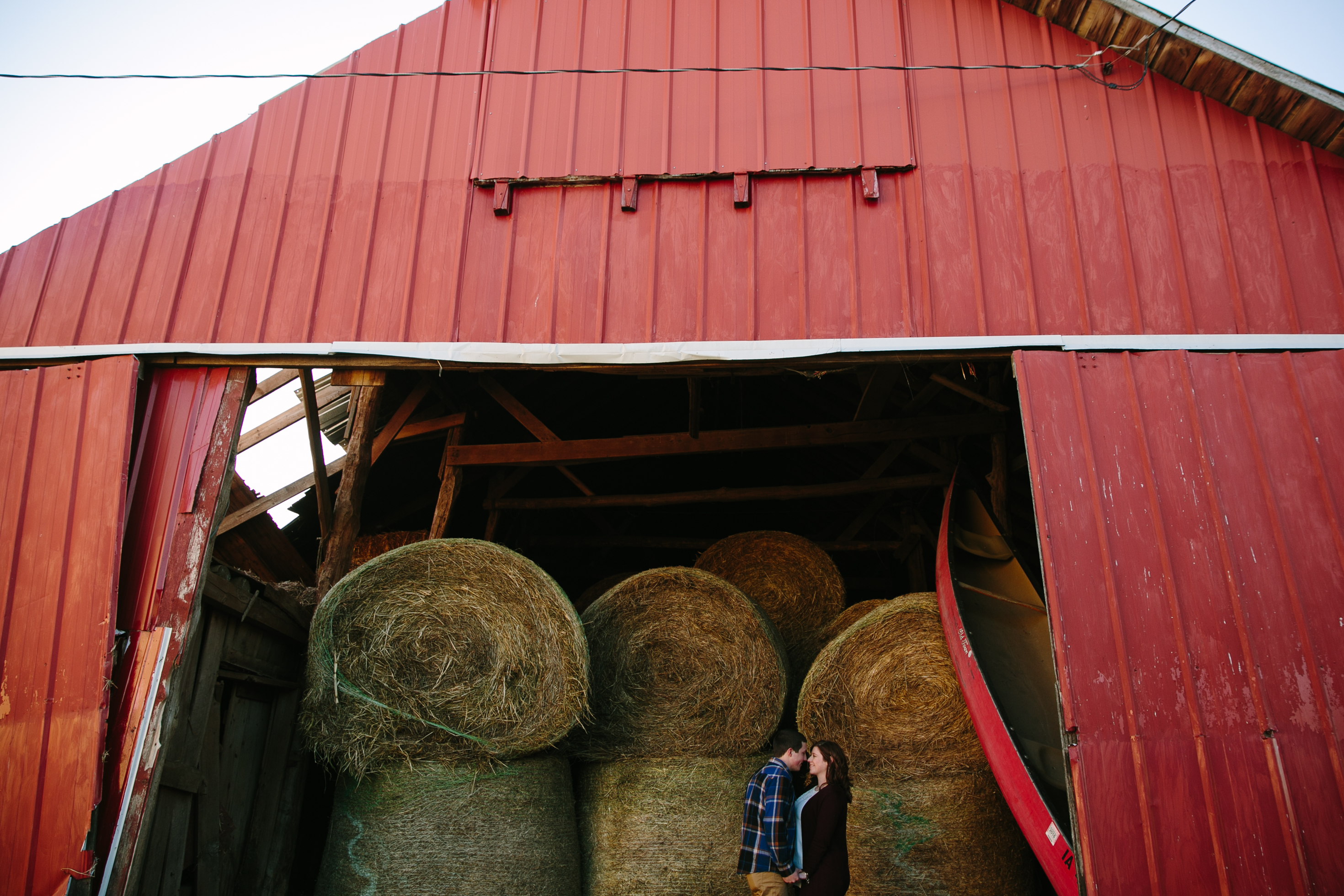 red barn with hay bails, iowa farm engagement session by catherine furlin photography