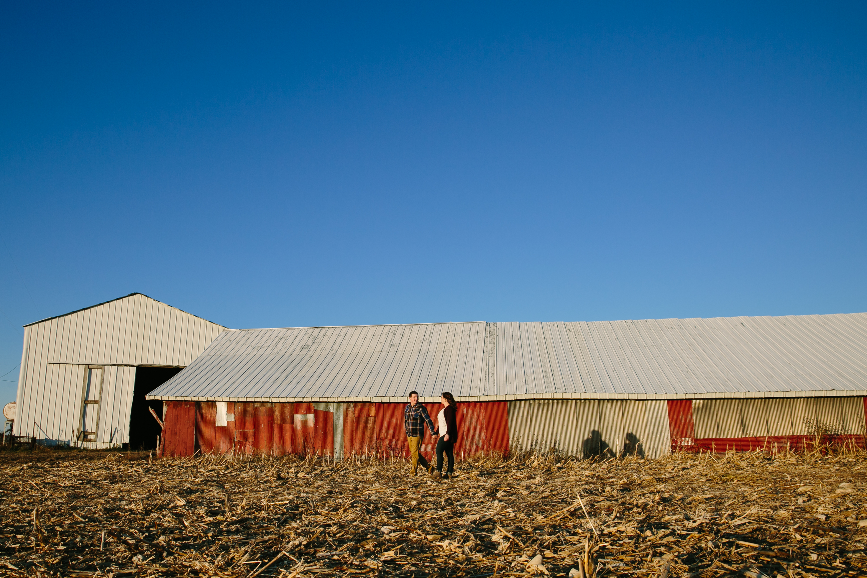 red barn and blue sky, iowa farm engagement session by catherine furlin photography
