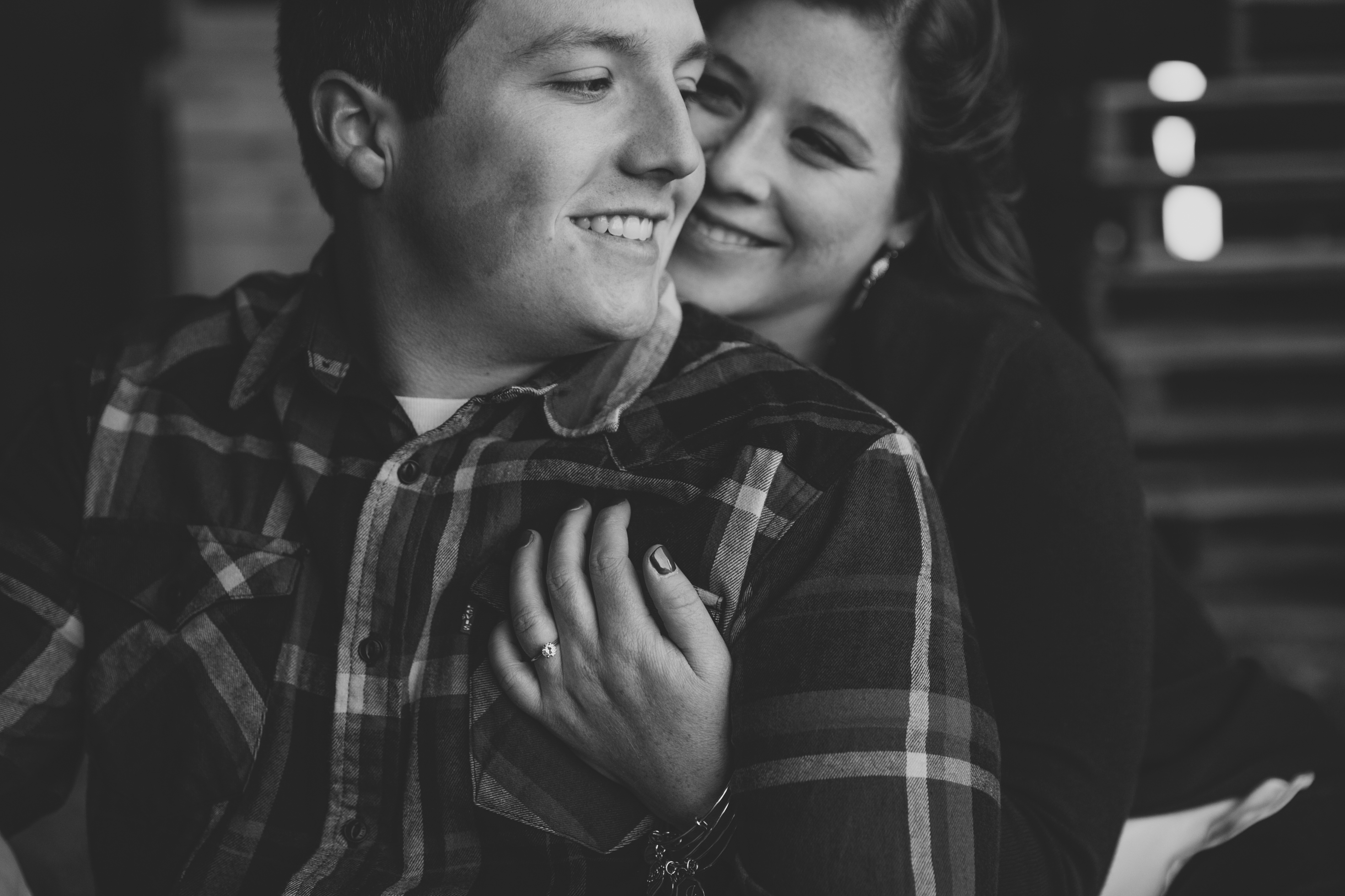 couple sitting in a barn, iowa farm engagement session by catherine furlin photography