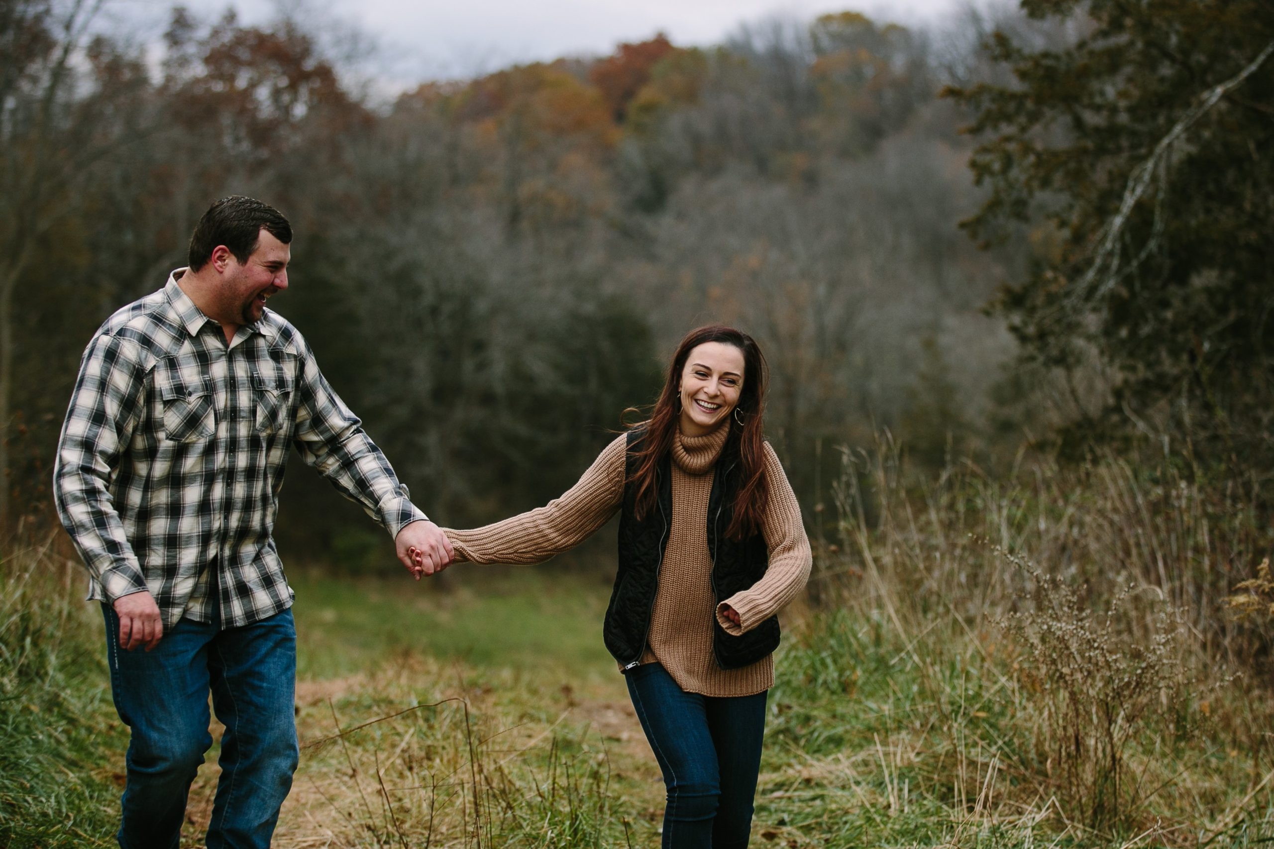 iowa couple holds hands while walking and laughing during engagement photos