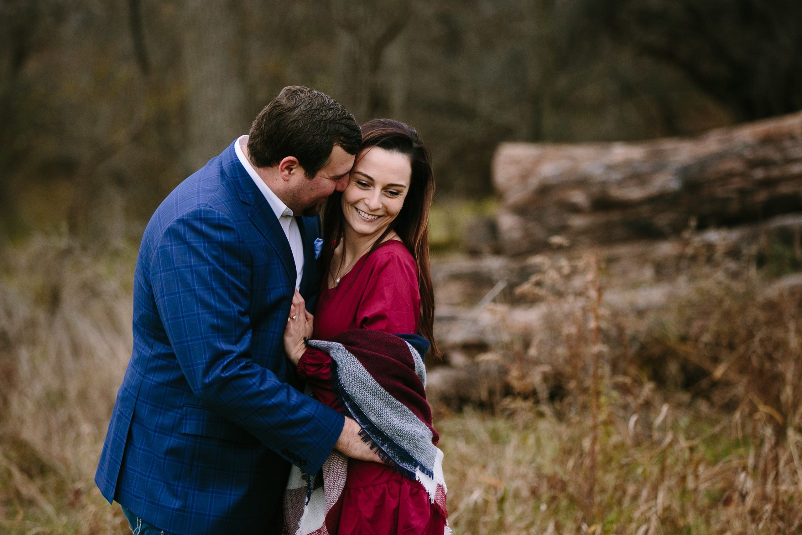 groom-to-be kissing his fiance on the cheek during iowa engagement session