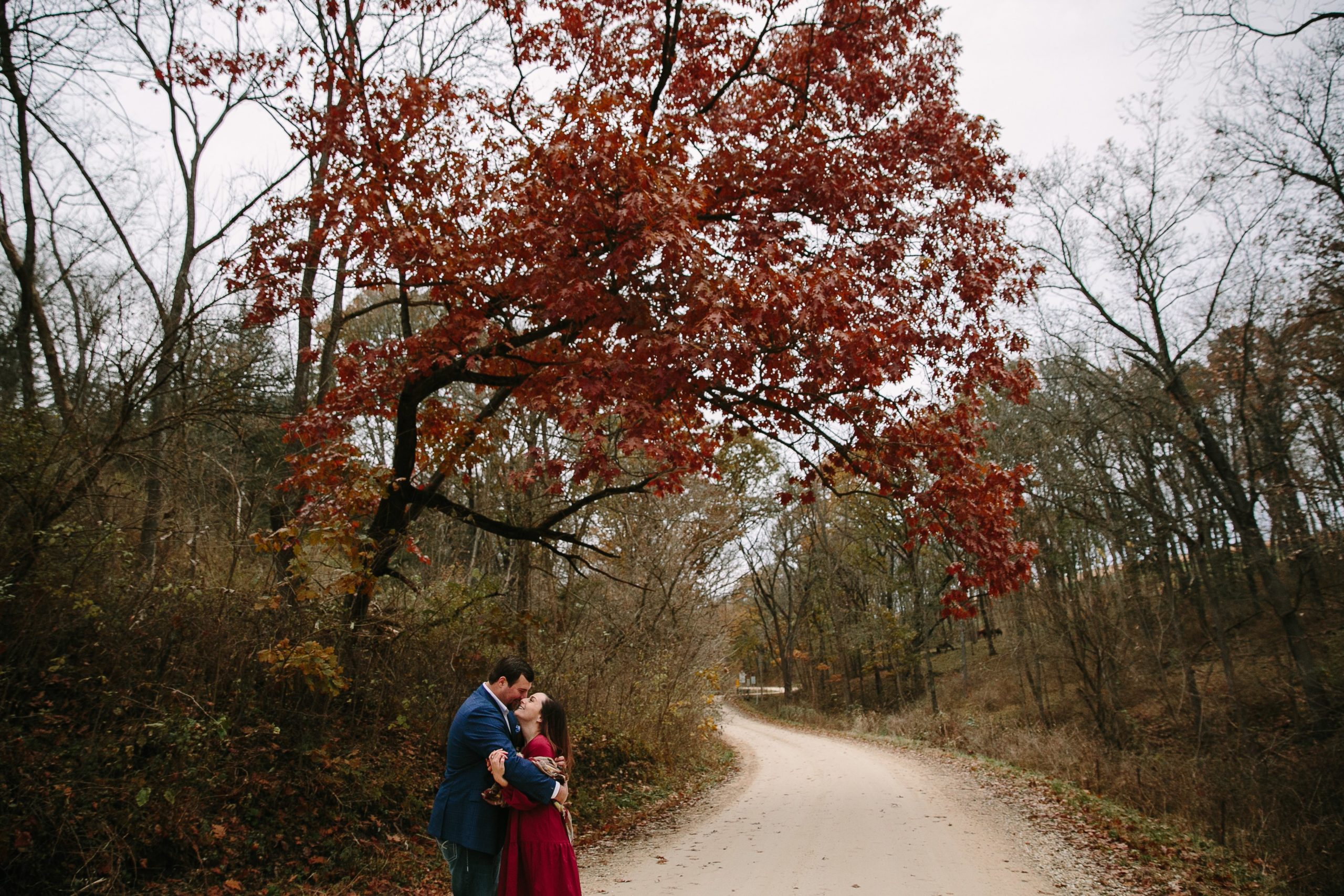 couple kissing on a gravel road during iowa engagement session