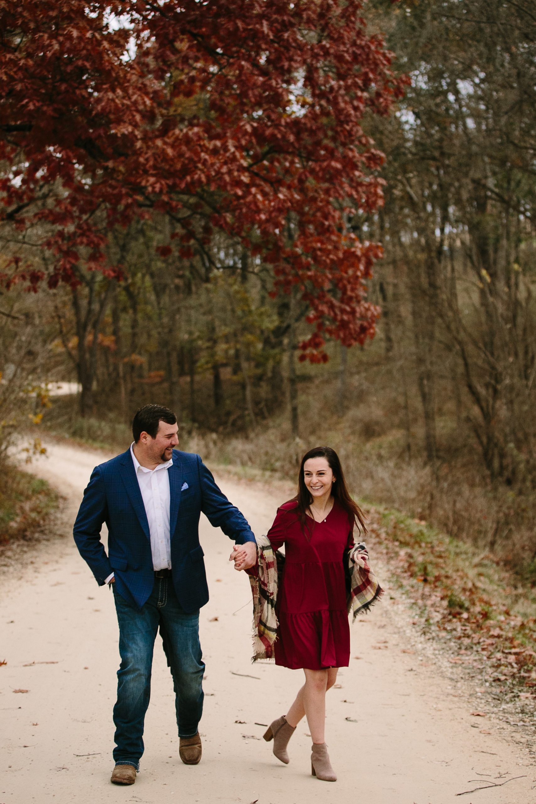 couple walking together on a gravel road during iowa engagement photos
