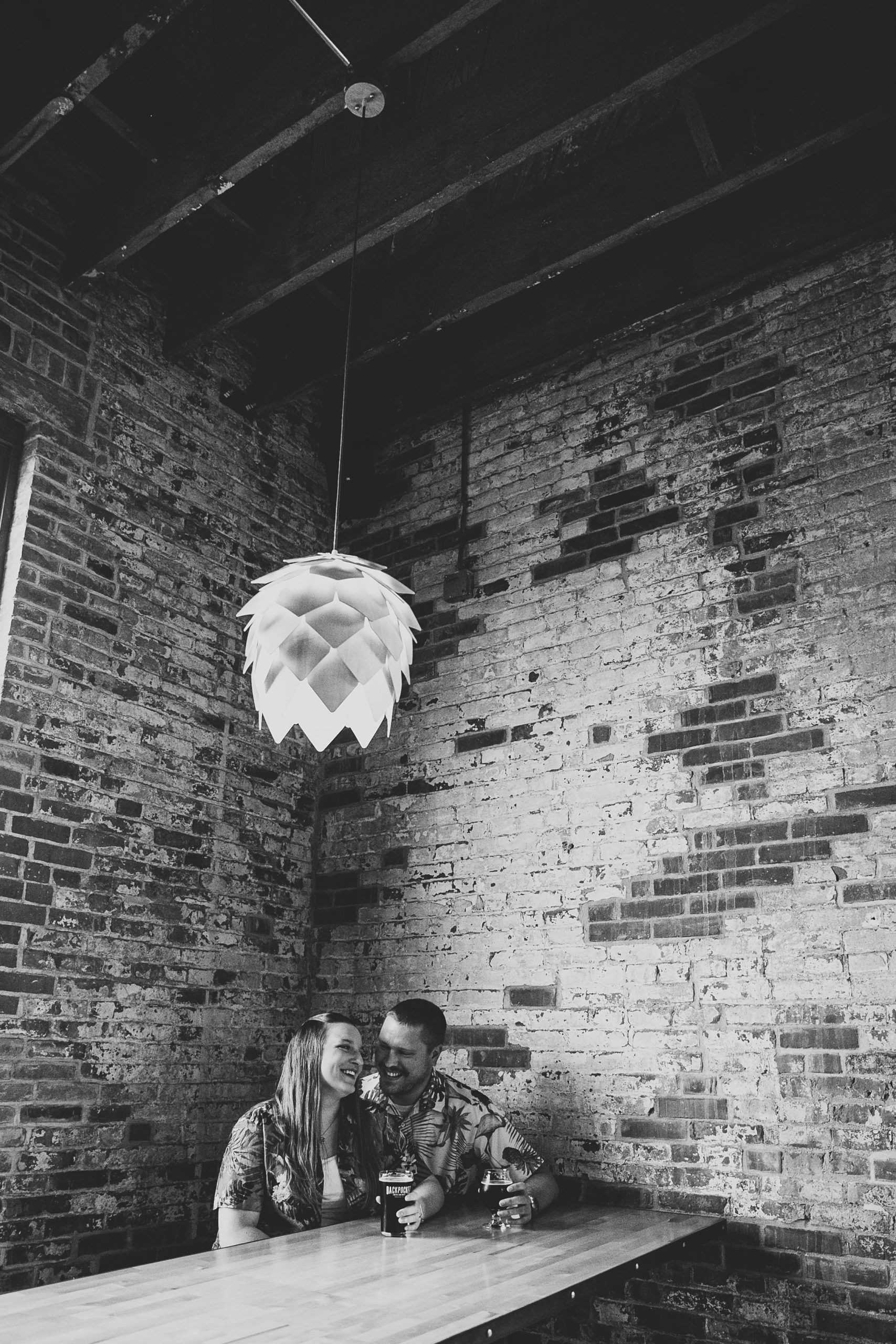 black and white photo of couple snuggling inside backpocket brewing during dubuque engagement session