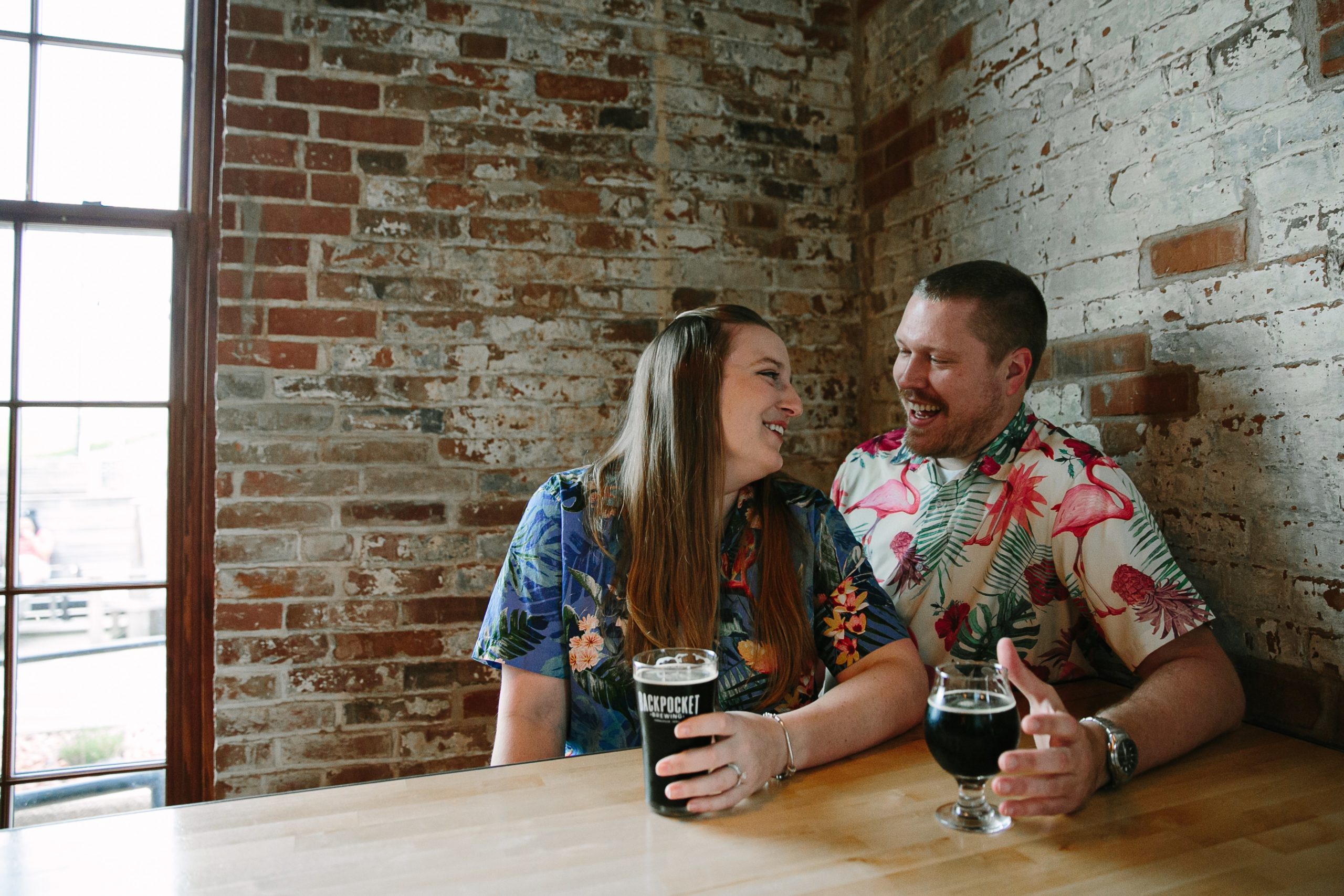 couple talking at table inside backpocket brewing during dubuque engagement session