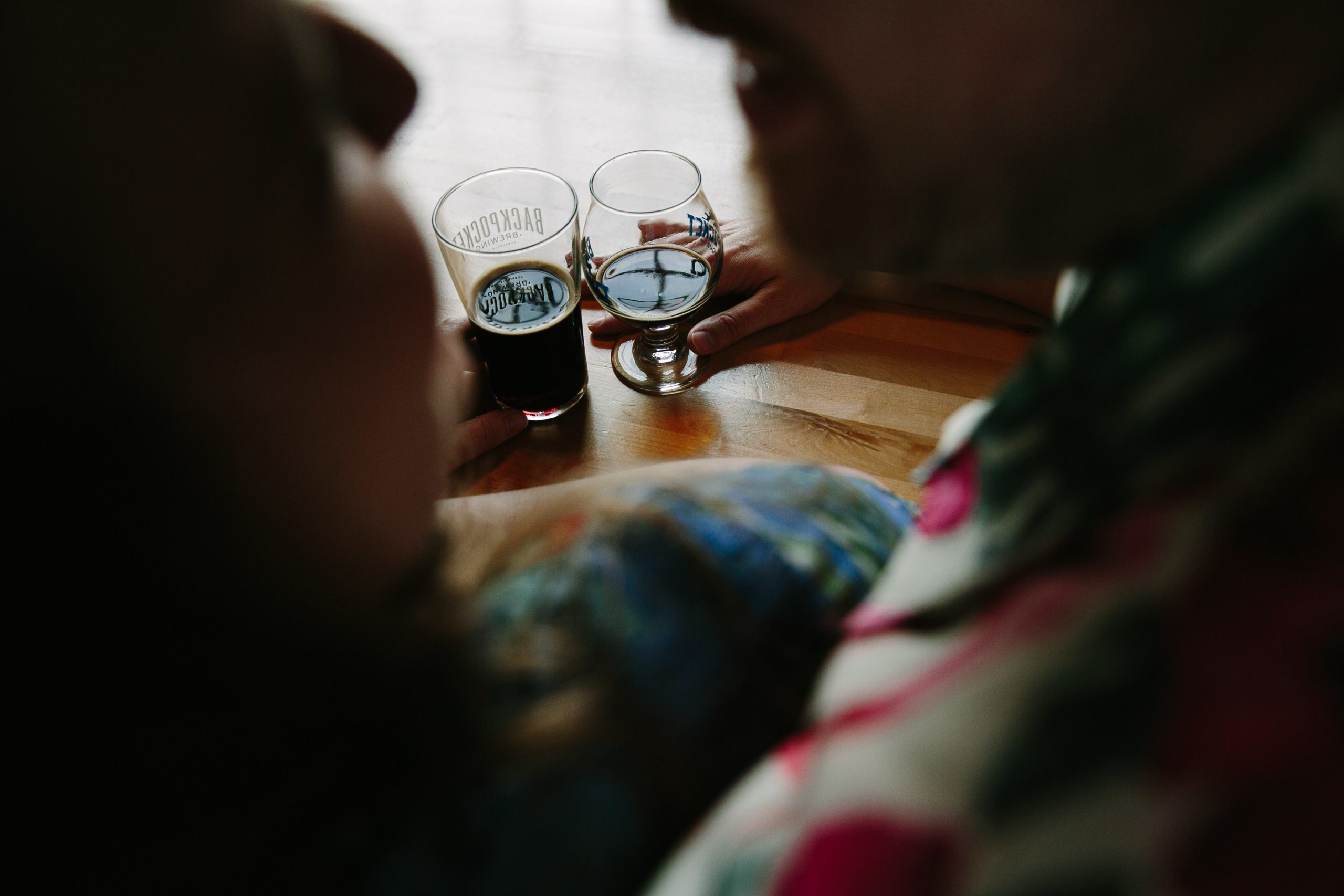 couple drinking at table inside backpocket brewing during dubuque engagement session