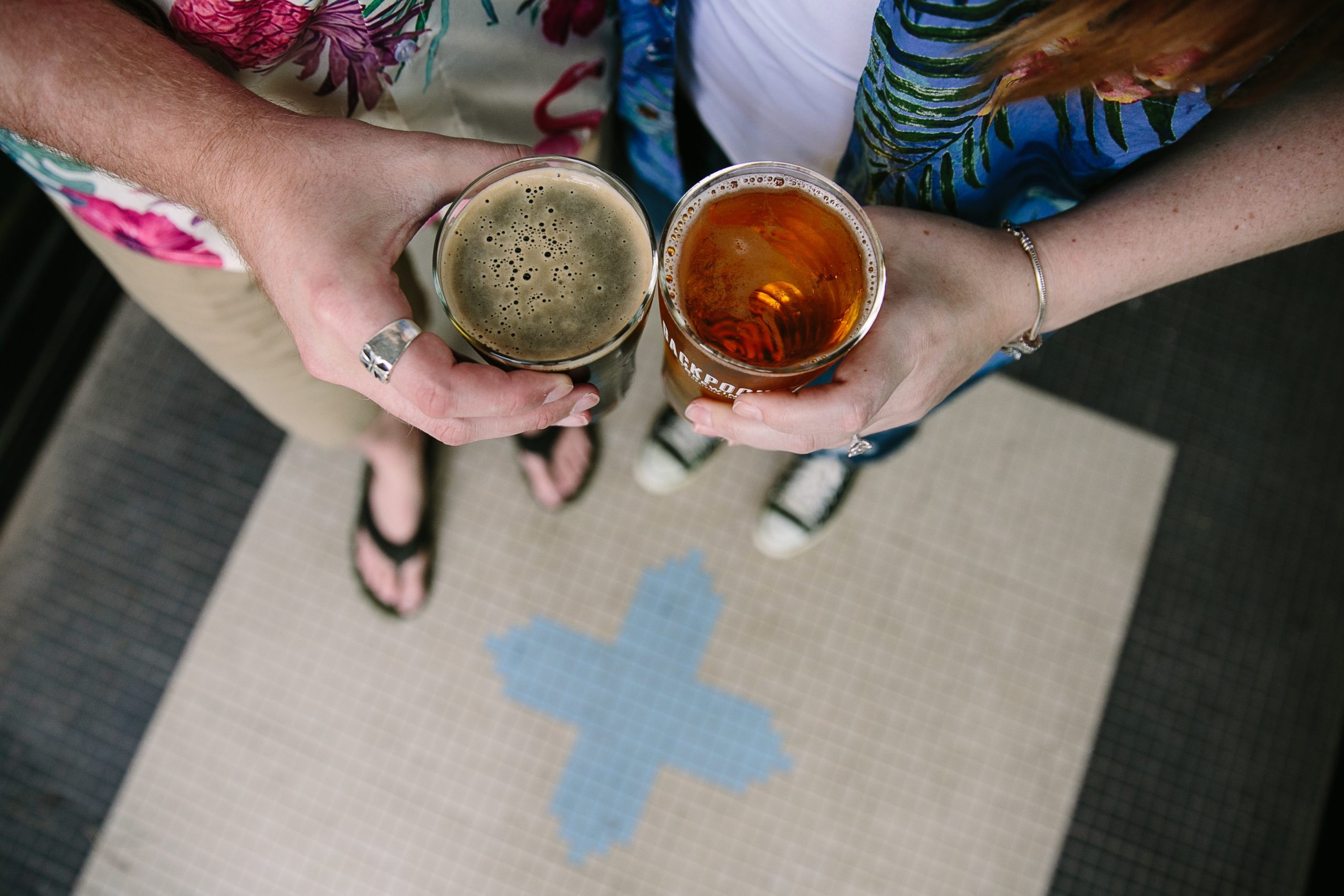 couple holds draft beer from backpocket brewing during dubuque engagement session
