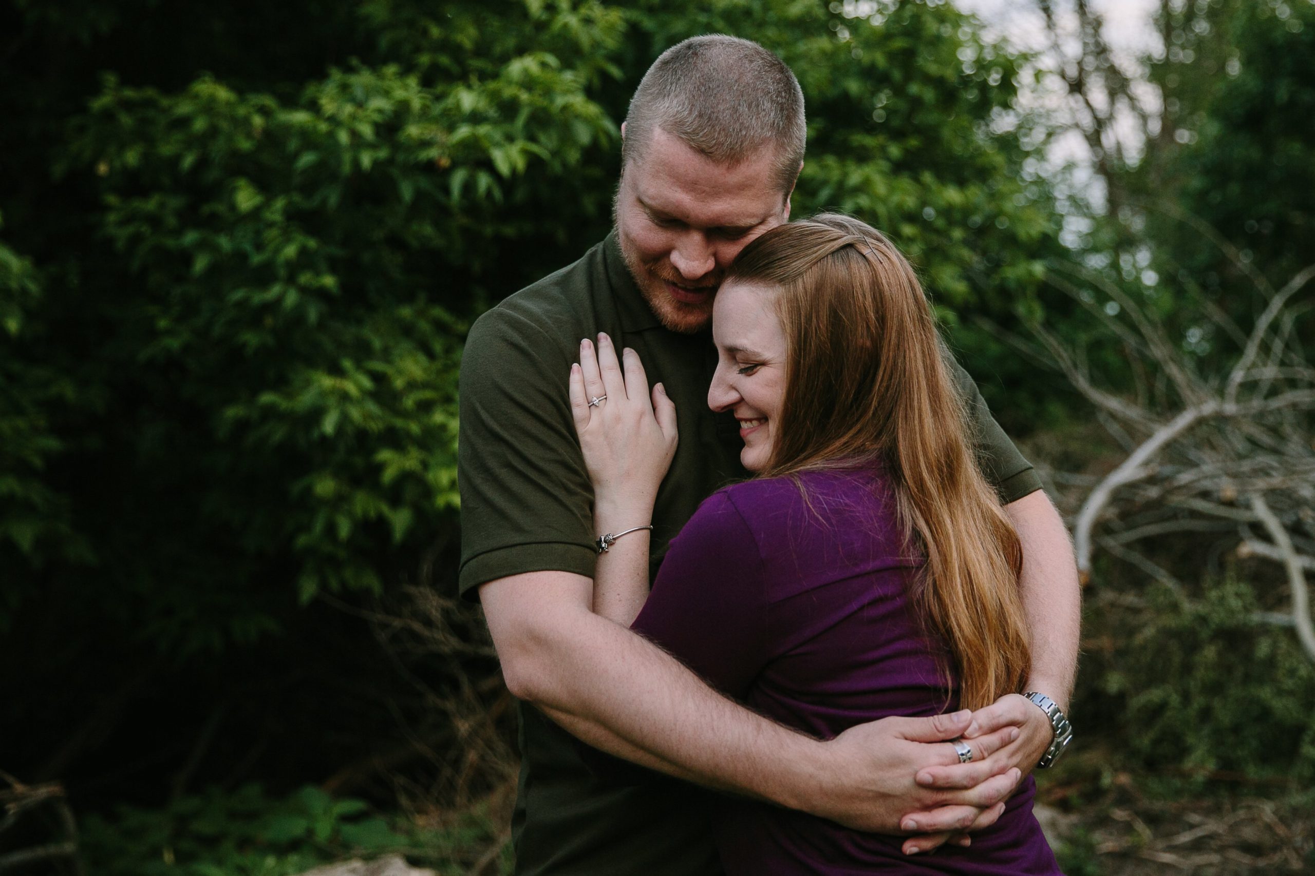 couple embraces during their outdoor dubuque engagement session at the mines of spain