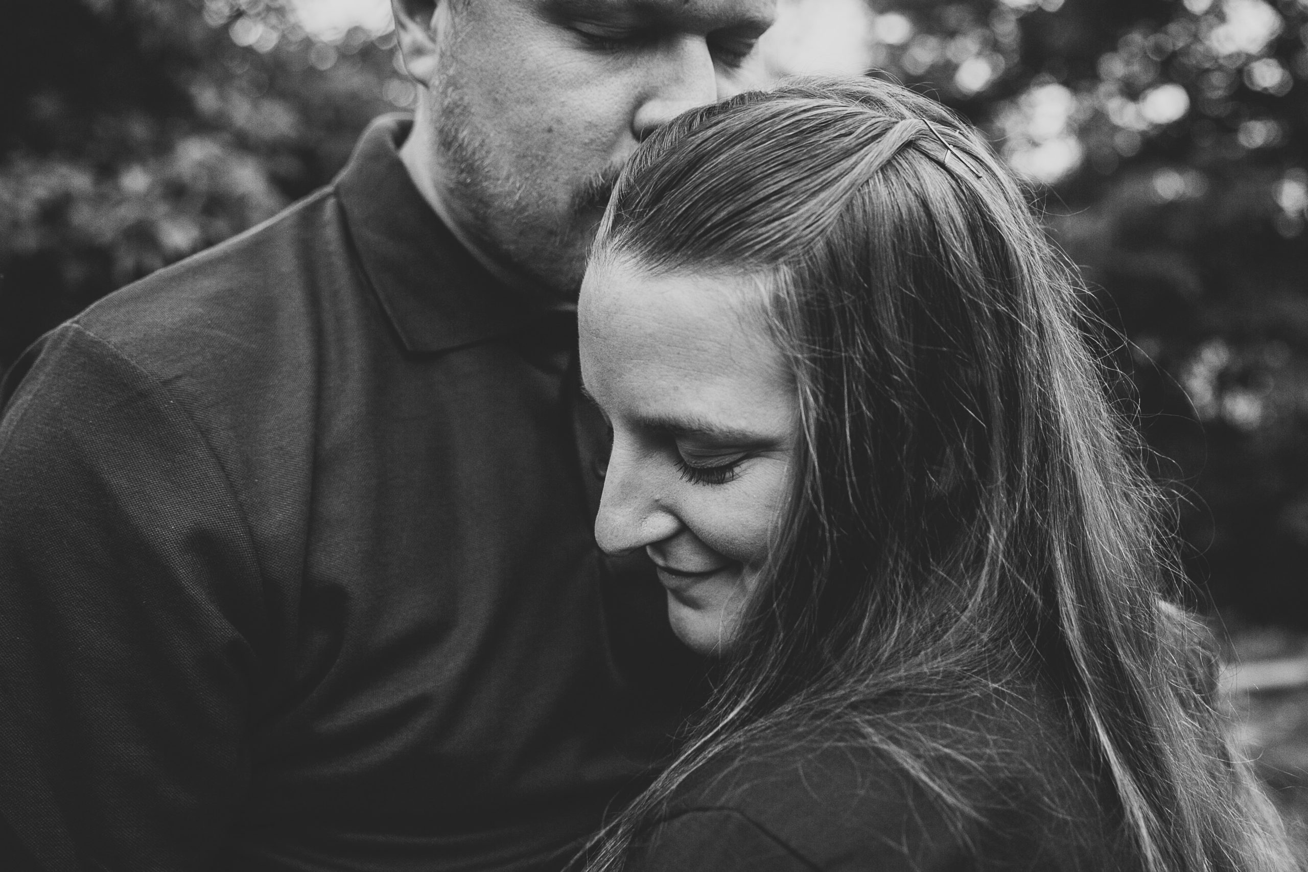 kissing fiance on the head during engagement photos in dubuque iowa