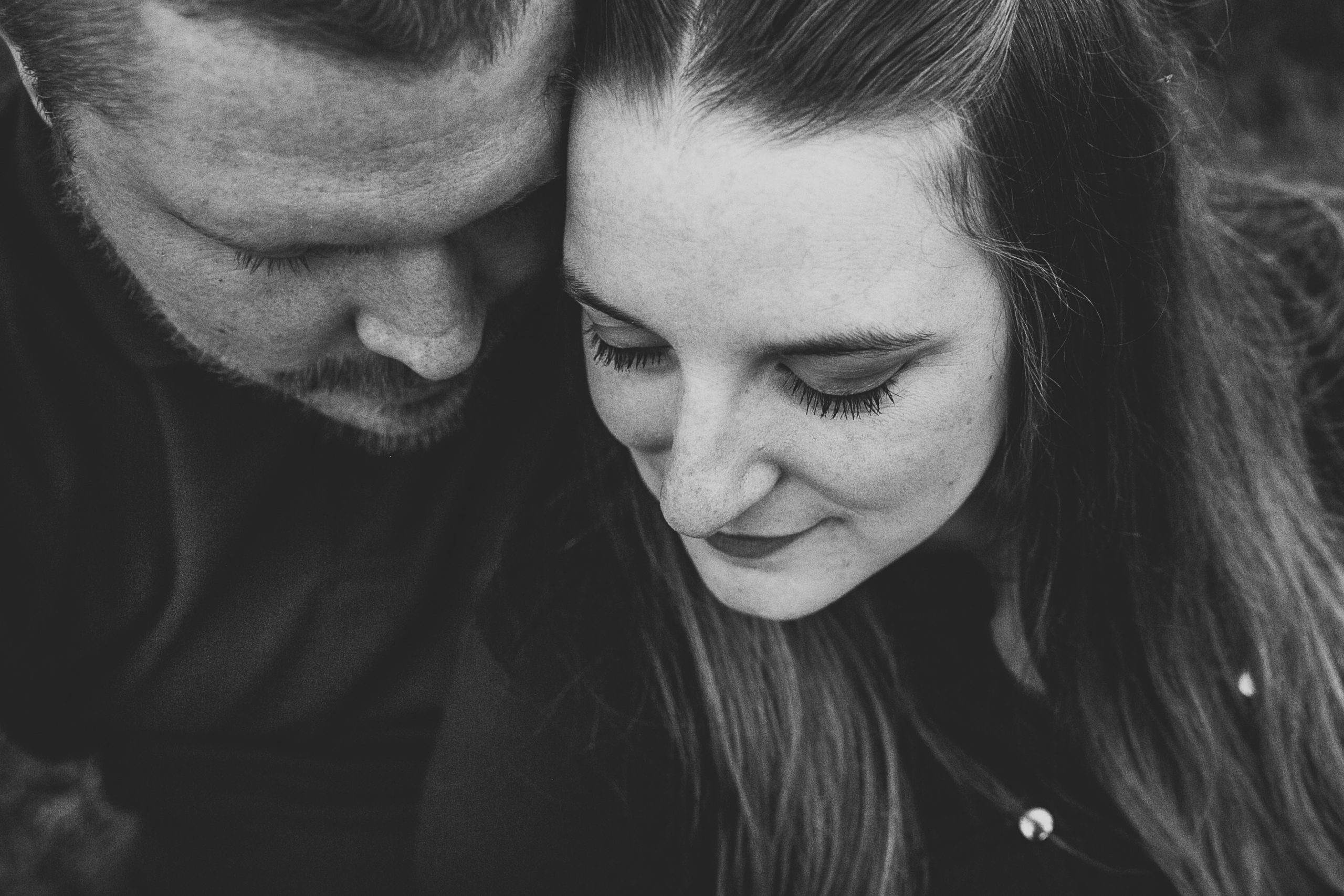 black and white photo of engaged couple snuggled up together in dubuque