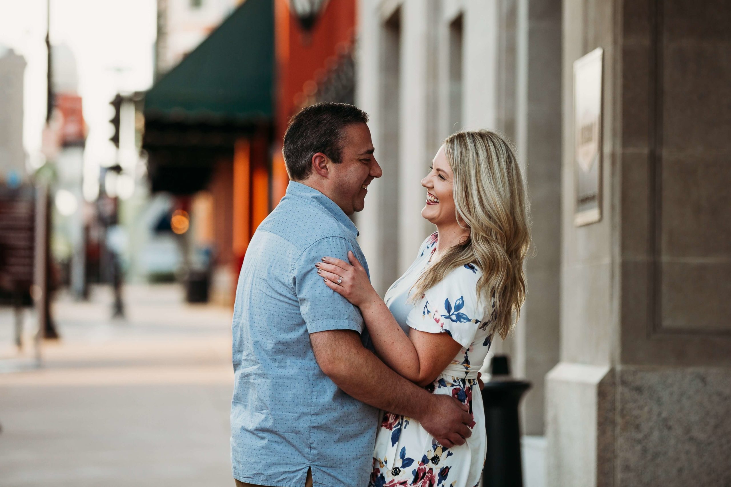 couple laughing together on a downtown dubuque sidewalk