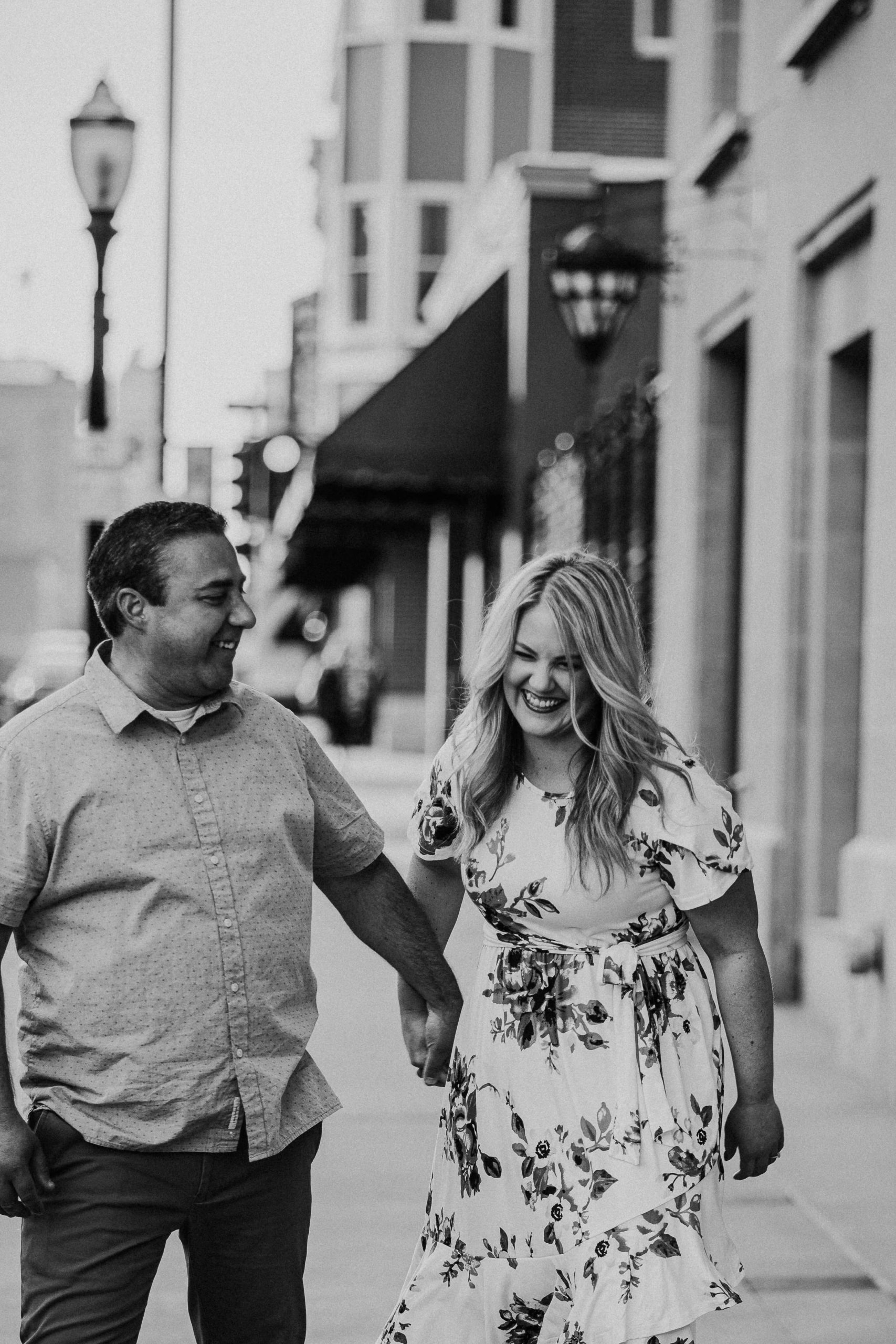 black and white photo of couple walking together on the sidewalk in downtown dubuque