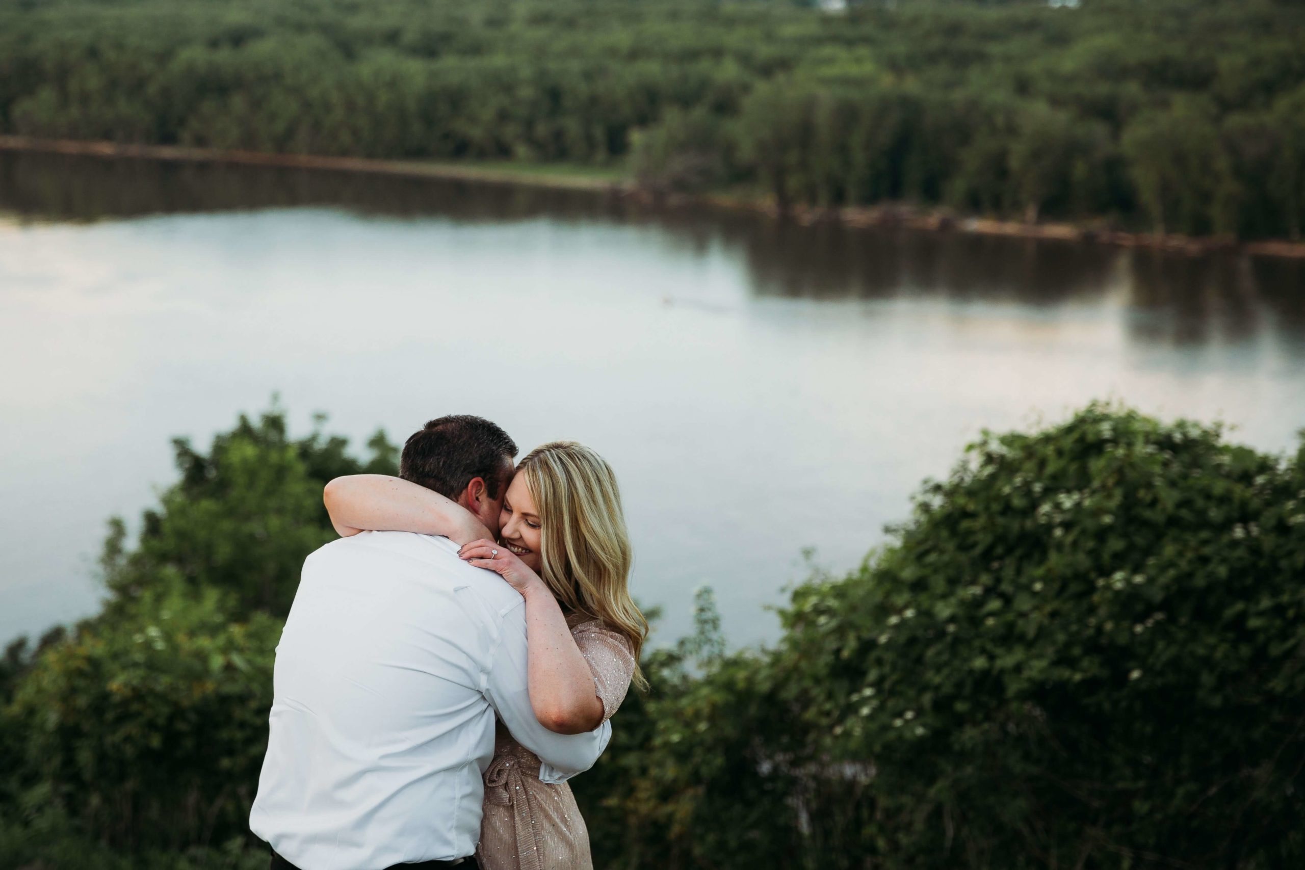 couple hugging with a view of the mississippi river in the background