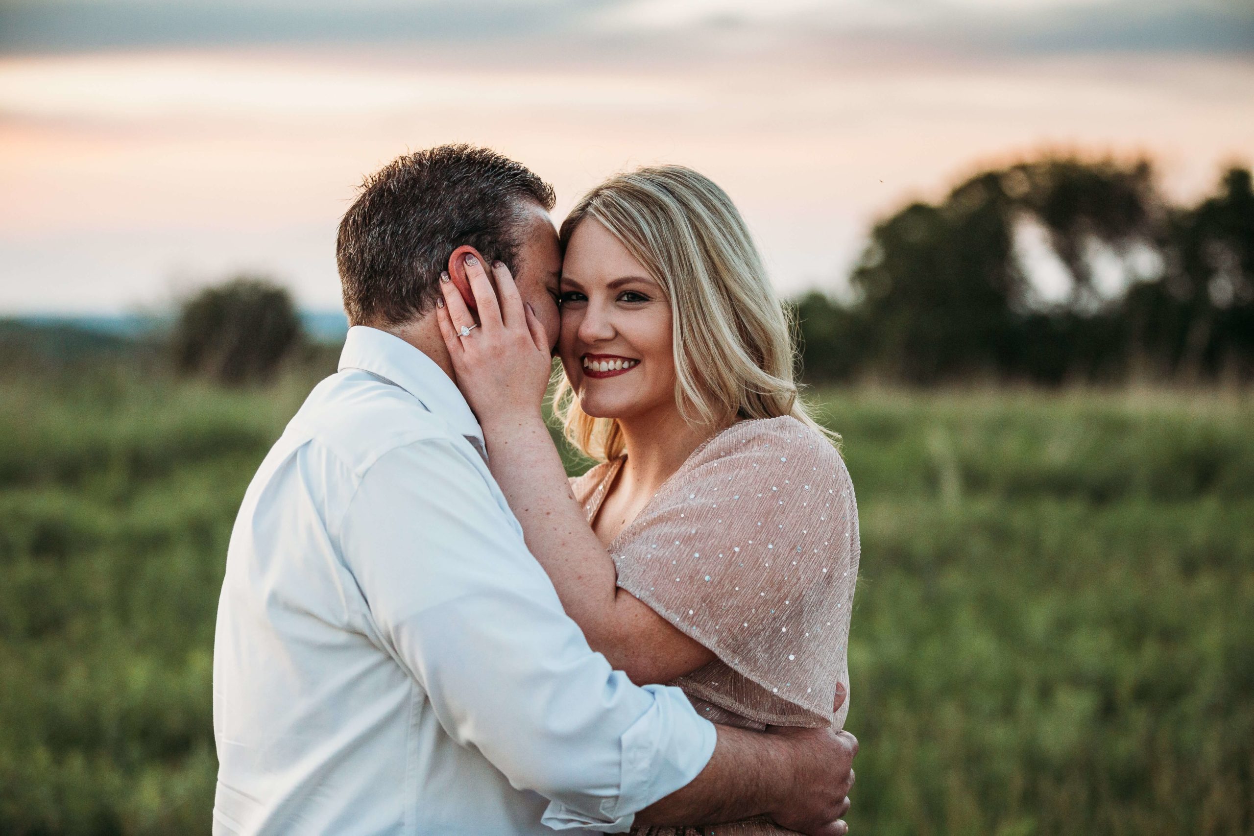 dubuque couple snuggling at sunset during their engagement session